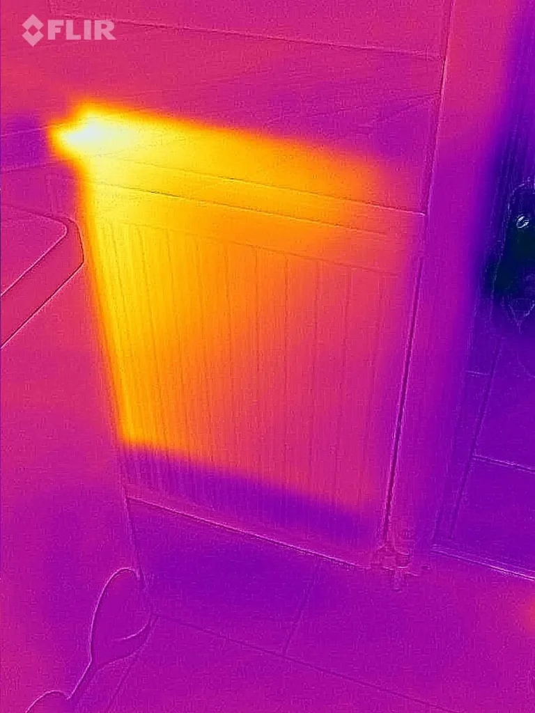 Thermal camera image of a radiator that is hot at the top and cold across the bottom third