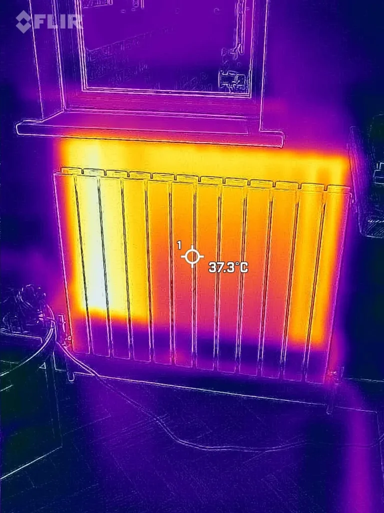 Thermal camera image of a radiator that is warm at the top and cold along the bottom