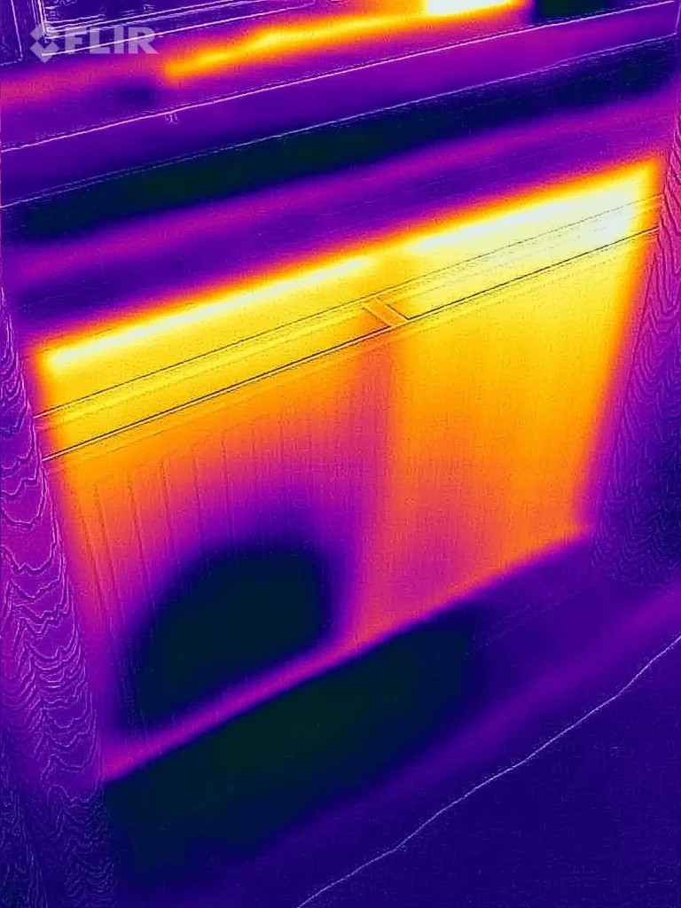 Thermal camera image of a radiator with a large cold patch at the bottom left